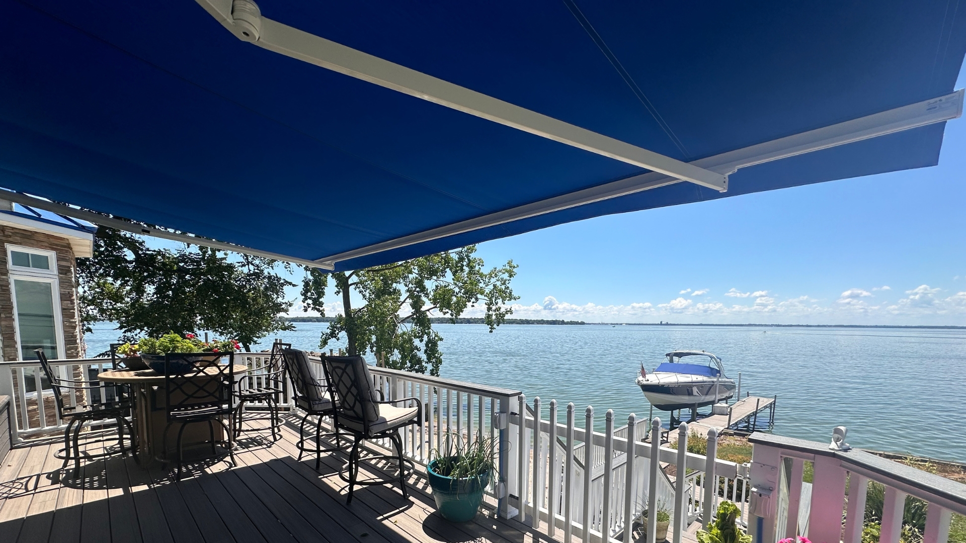 Blue retractable awning shading a lakefront deck