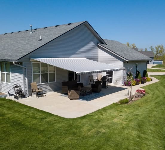Idyllic suburban home with a backyard patio shaded by a Sunesta awning.